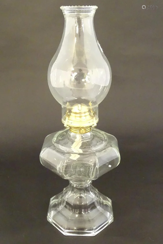 A 20thC clear glass oil lamp of octagonal form. 18''