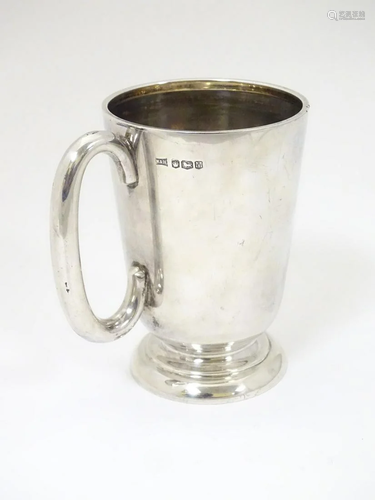 A silver mug with loop handles hallmarked Sheffield