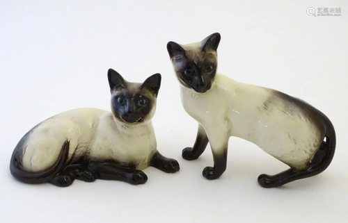 Two Beswick siamese cats, one standing and one