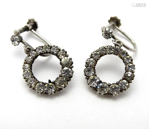 A pair of silver drop earrings set with white stones.