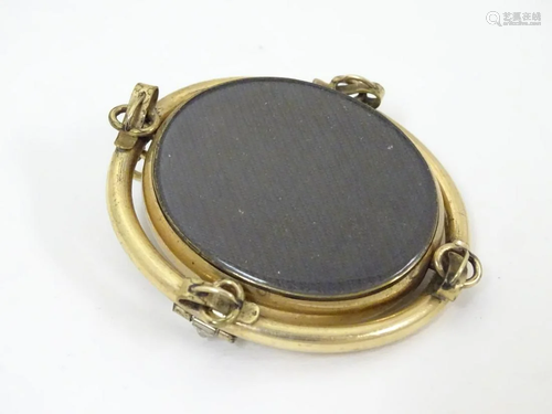 A Victorian gilt metal brooch with central oval