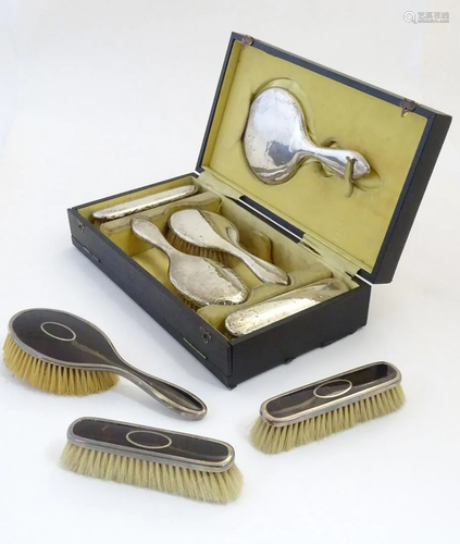 A cased dressing table set comprising silver backed