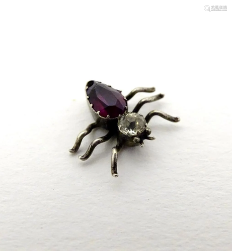 A small charm formed as an insect with amethyst