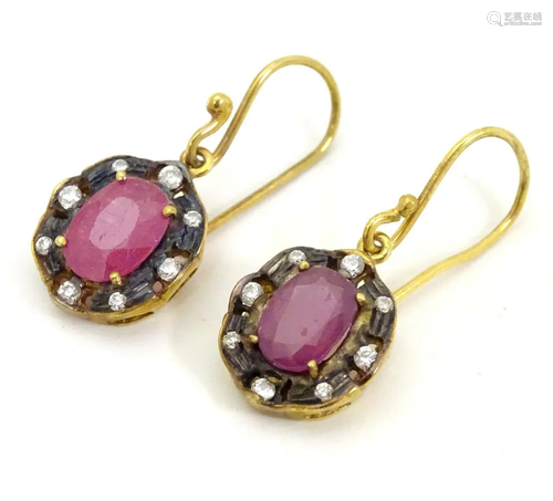 A pair of gilt metal drop earrings set with red and