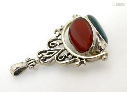 A silver pendant fob seal with rotating central