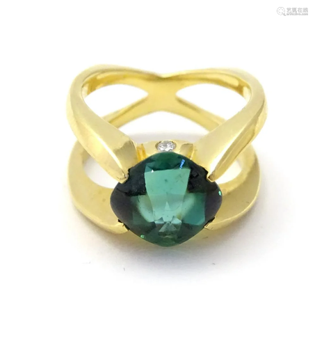 A gold ring set with central green tourmaline flan…