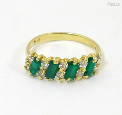 An 18ct gold ring set with green and white stones