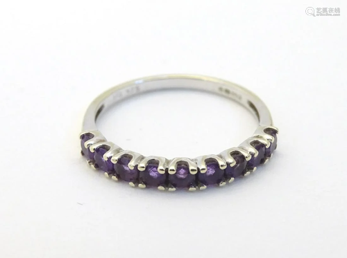 A 9ct gold ring set with 9 amethysts in a linear