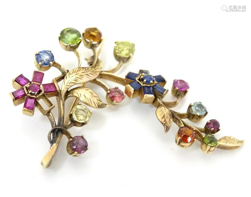 A gold brooch of floral foliate form set with a