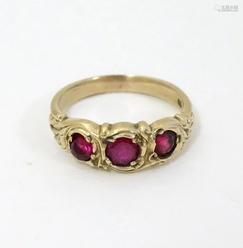 A yellow metal ring set with graduated rubies.