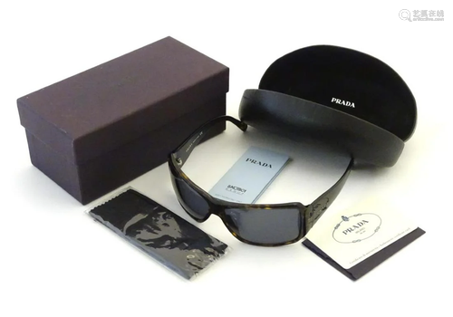 A pair of Prada sunglasses with original cas…