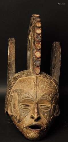 Nigéria Ethnie IGBO Masque de jeune fille dit Agbogho muo. Coiffure complexe à triple cimier sculpté d'éléments géométriques et de deux caméléons Le visage est finement sculpté, le nez busqué, la bouche ouverte et de nombreuses scarifications. Traces de polychromie. H: 52 cm x P: 27 cm