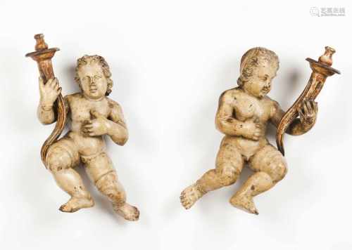 A pair of candle holding cherubs