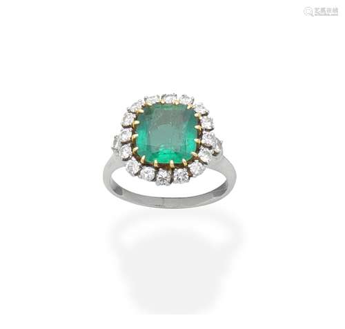 An emerald and diamond cluster ring