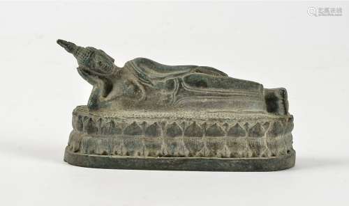 A patinated metal figure of a reclining deity, length 8.5cm