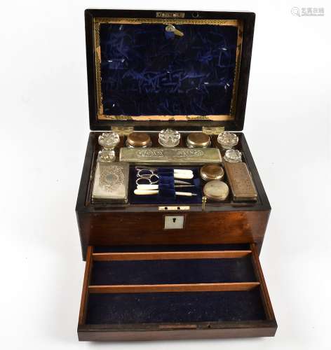 A Victorian walnut dressing box, the hinged lid and escutcheon inset with mother of pearl, opening