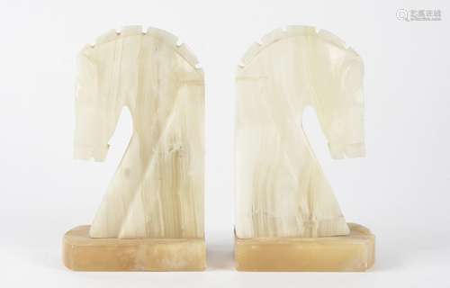 A pair of banded calcite bookends, modelled as horse heads, height 18cm (2)