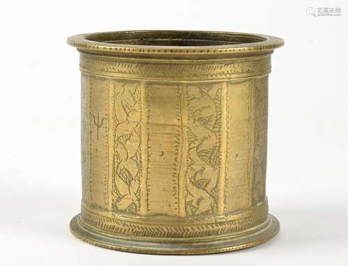 A cylindrical brass vessel, possibly an Indian mortar, with engraved trishula symbol to one panel,