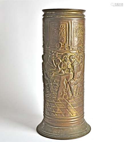 A cylindrical copper umbrella stand, embossed with a scene of figures socialising around a table,