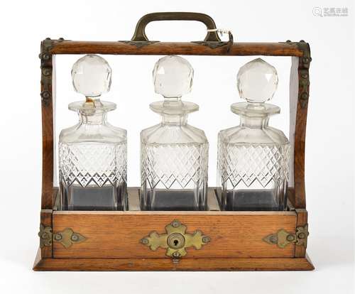 A 19th Century oak three bottle tantalus, with brass fittings, together with three moulded glass