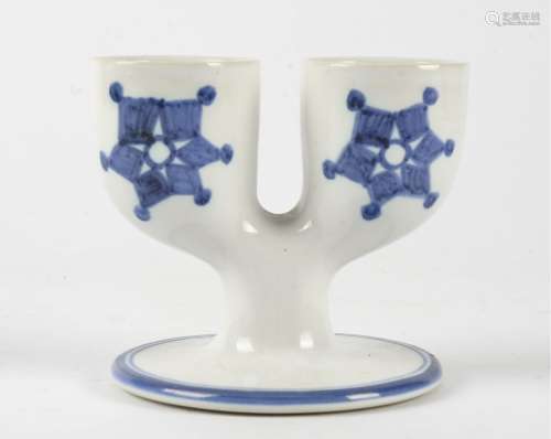 A Troika double egg cup, on a circular base, glazed in white with blue hand painted decoration,