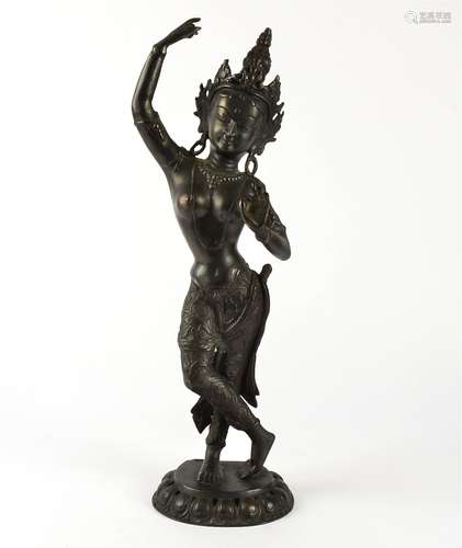 A Balinese cast bronze figure of a semi-nude woman, dressed in traditional attire including a