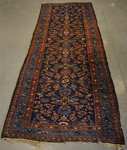A 20th Century woollen runner, the central panel decorated with foliage upon a blue ground,