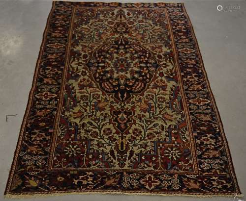 A 20th Century woollen rug, with a central blue medallion, upon a cream and red floral ground,