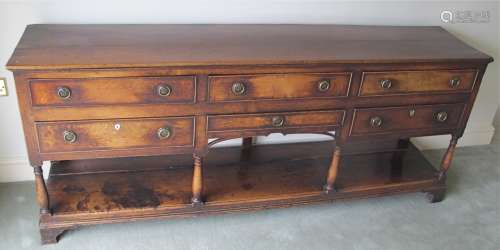 A 19th Century elm and oak dresser, with six cross banded drawers, brass ring pull handles,