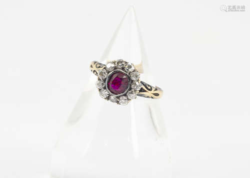 An early 20th Century ruby and diamond cluster ring, the oval mixed cut ruby surrounded by a bezel