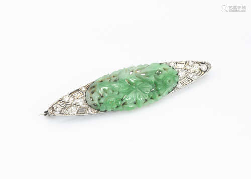 An Art Deco diamond, jade, platinum and 18ct gold brooch, the central Chinese carved green jade oval