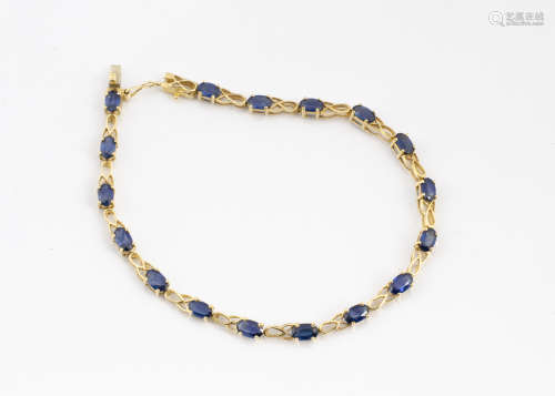 A continental yellow metal and sapphire line bracelet, the oval mixed cut sapphires in pierced