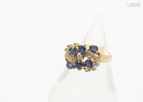 A 14ct gold sapphire and diamond dress ring, the oval cut sapphires in claw setting surrounded by