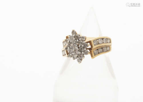 A diamond cluster ring, the central oval cluster with claw set brilliant cuts on a crossover setting