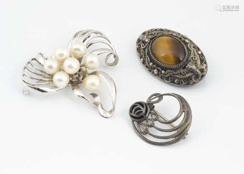A Chinese and tiger's eye filigree brooch, marked silver verso, a silver and onyx Art Nouveau brooch