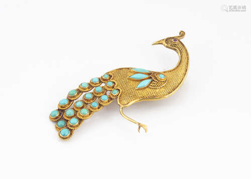 A continental yellow metal turquoise and ruby set peacock brooch, the filigree body in yellow