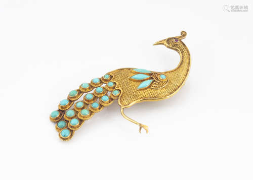 A continental yellow metal turquoise and ruby set peacock brooch, the filigree body in yellow
