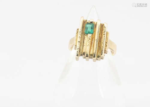 An 18ct gold and emerald set dress ring, in the retro style, the setting of linear textured design