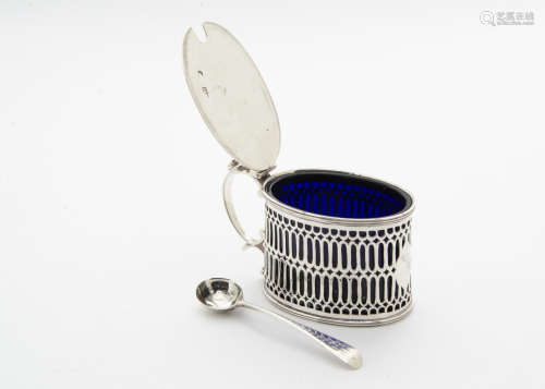 A George III silver mustard pot by T.H, oval with pierced sides, with a blue glass liner and similar