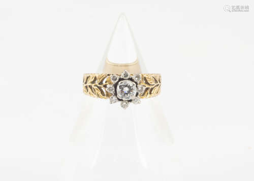 A continental yellow metal and diamond cluster dress ring, the raised brilliant cut diamond in a