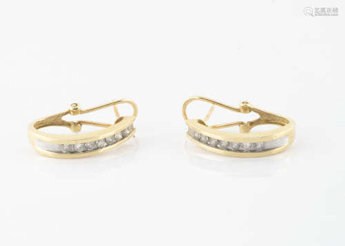 A pair of 14ct gold and diamond set earrings, the channel set brilliant cuts in a hoop setting