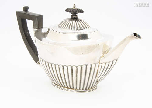 A George V silver teapot from Mappin & Webb, Sheffield 1926, with fluted lower and applied black