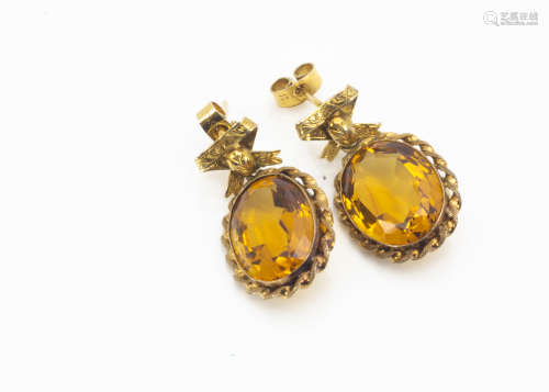 A pair of citrine drop earrings, the oval mixed cut in a rope twist setting supported on bow set
