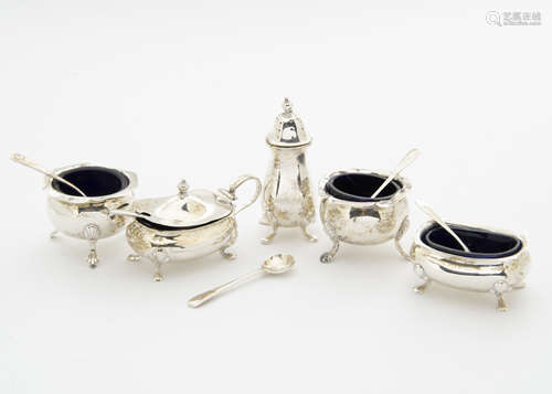 A five piece George V period silver cruet items, with blue glass liners and four spoons, one