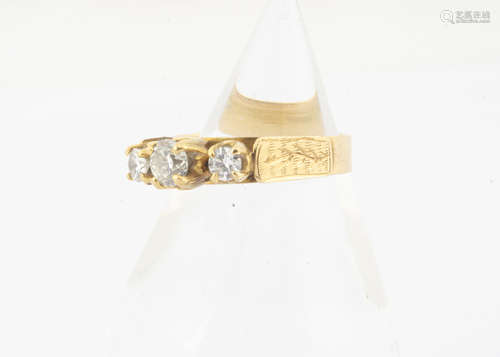 A three stone diamond yellow metal dress ring, the three claw set diamonds on a raised setting