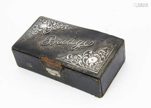 An Edwardian bridge box, black leatherette with silver mounts and word Bridge, with some cards