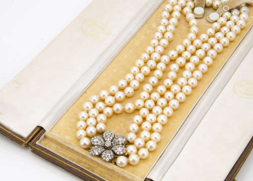 A three strand uniform cultured pearl necklace, with ornate diamond floral clasp, the knotted strung