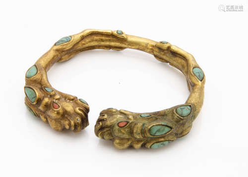 A gilded bronze coral and turquoise Chinese torque bangle, of mythical beast style with coral