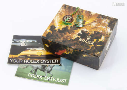 A Rolex outer cardboard box, with a Rolex plastic retail tag and another tag and booklet