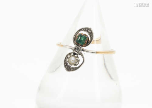 A Belle Epoque emerald, diamond and pearl set dress ring, the platinum set gems in a scroll